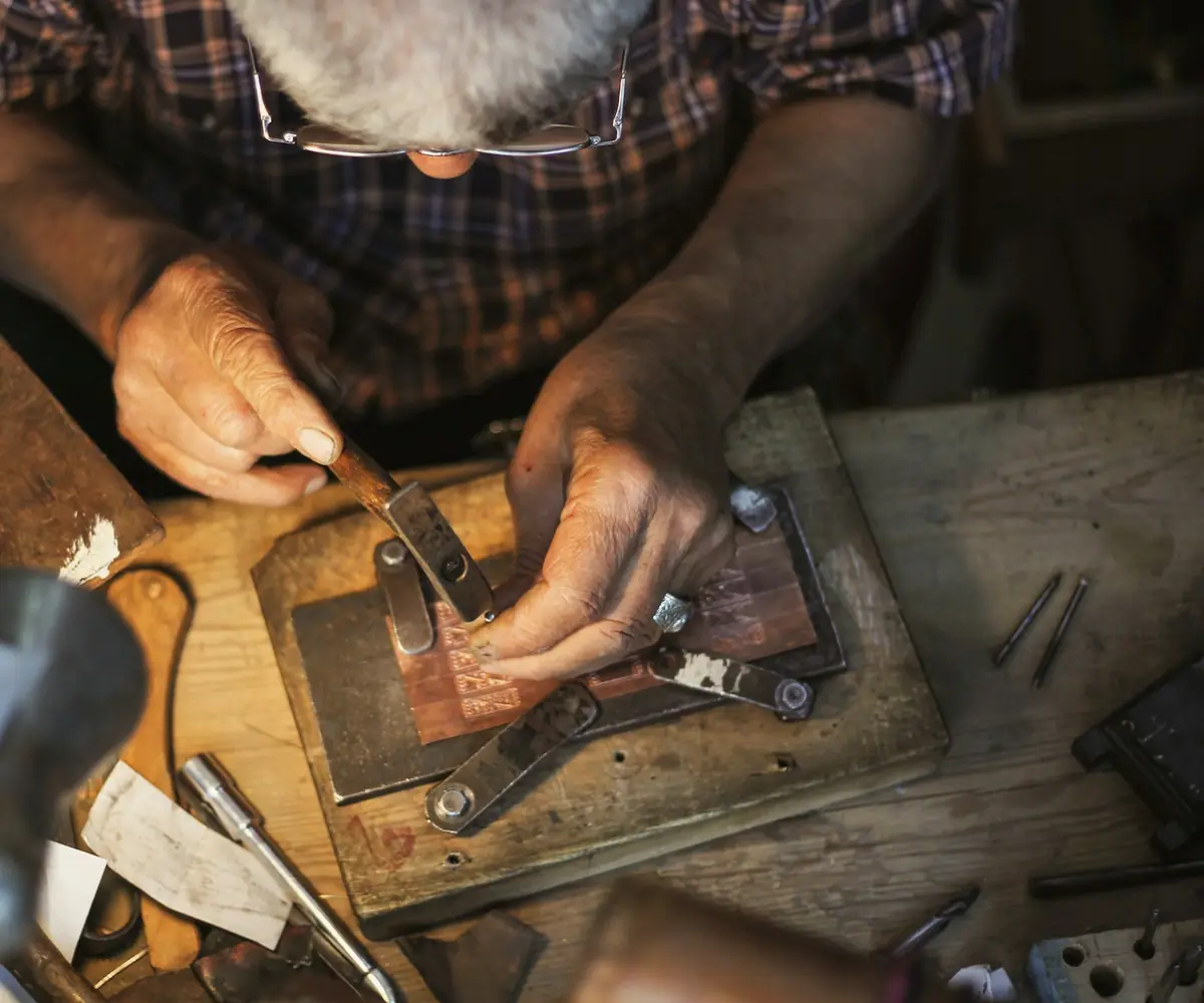 Craftsman finishing a metal piece by hand
