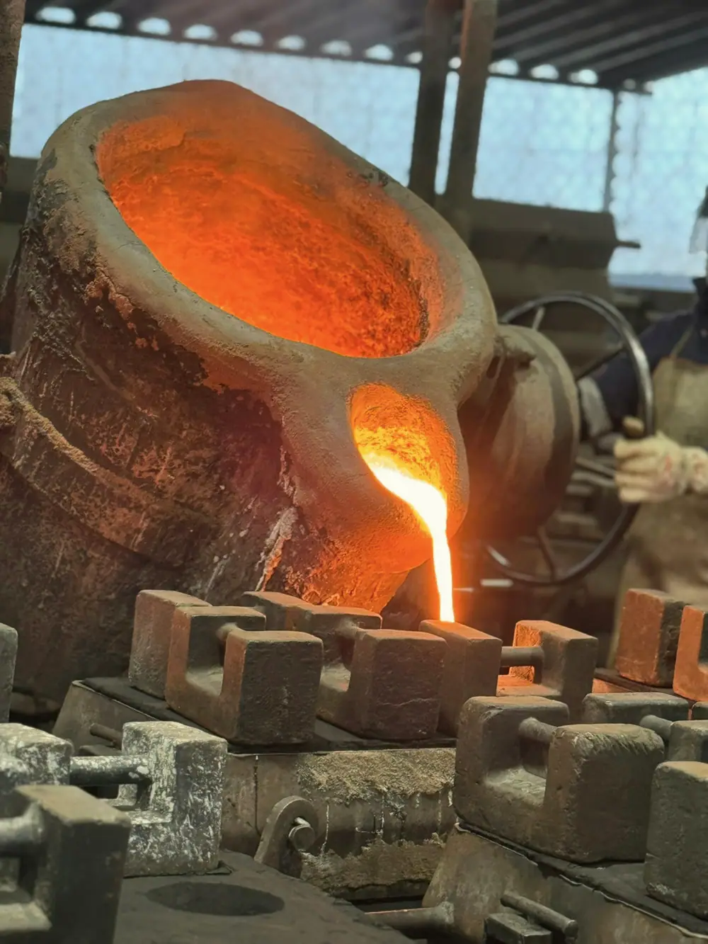 Molten metal being poured into sand moulds